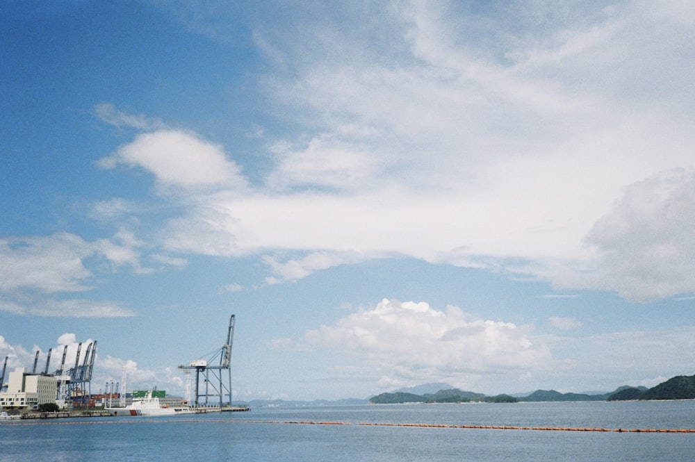 a body of water with a crane and buildings in the background