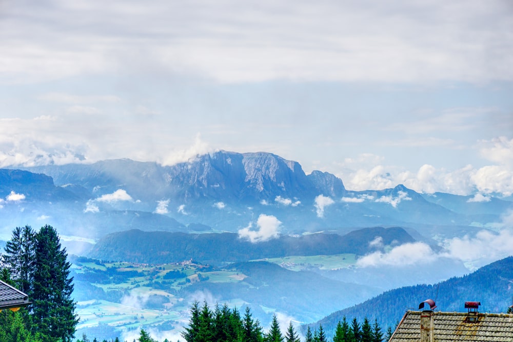 a view of a mountain range and clouds from a building