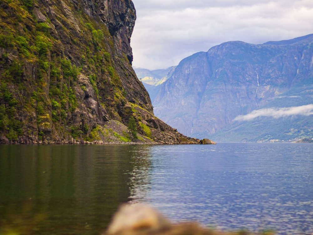 a body of water with mountains in the back