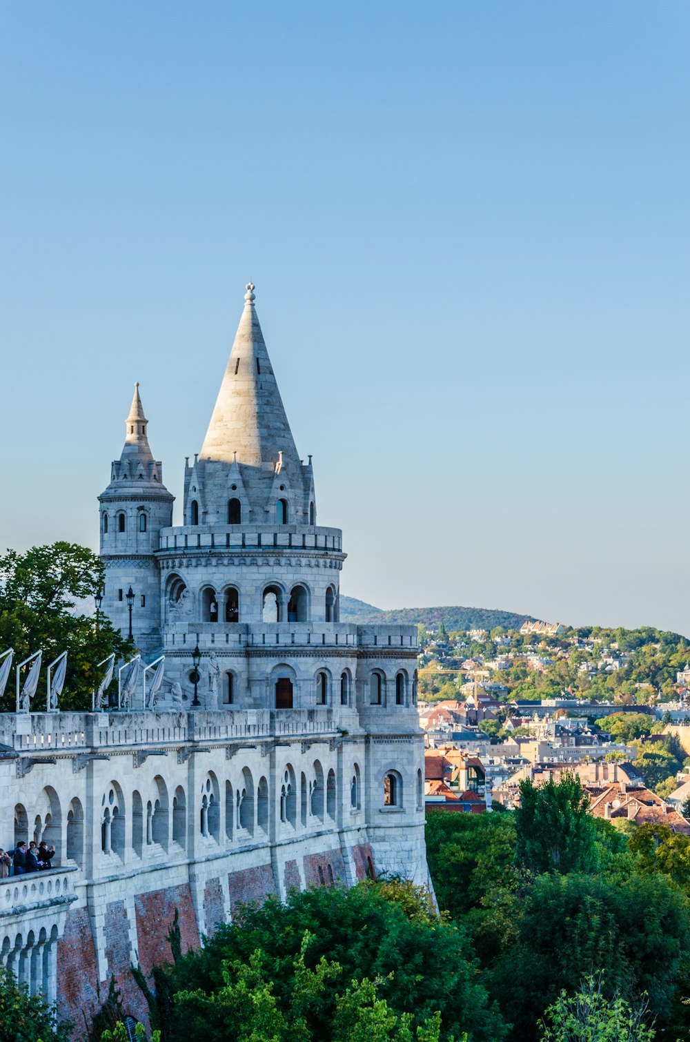 a large white building with a steeple and a city below