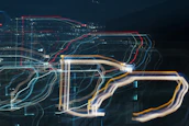 Abstract digital flow lines in black and gold weaving through a modern city skyline at dusk.