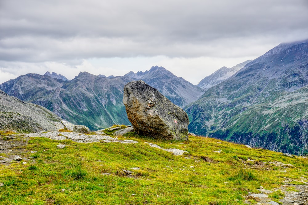 a large rock on a grassy hill