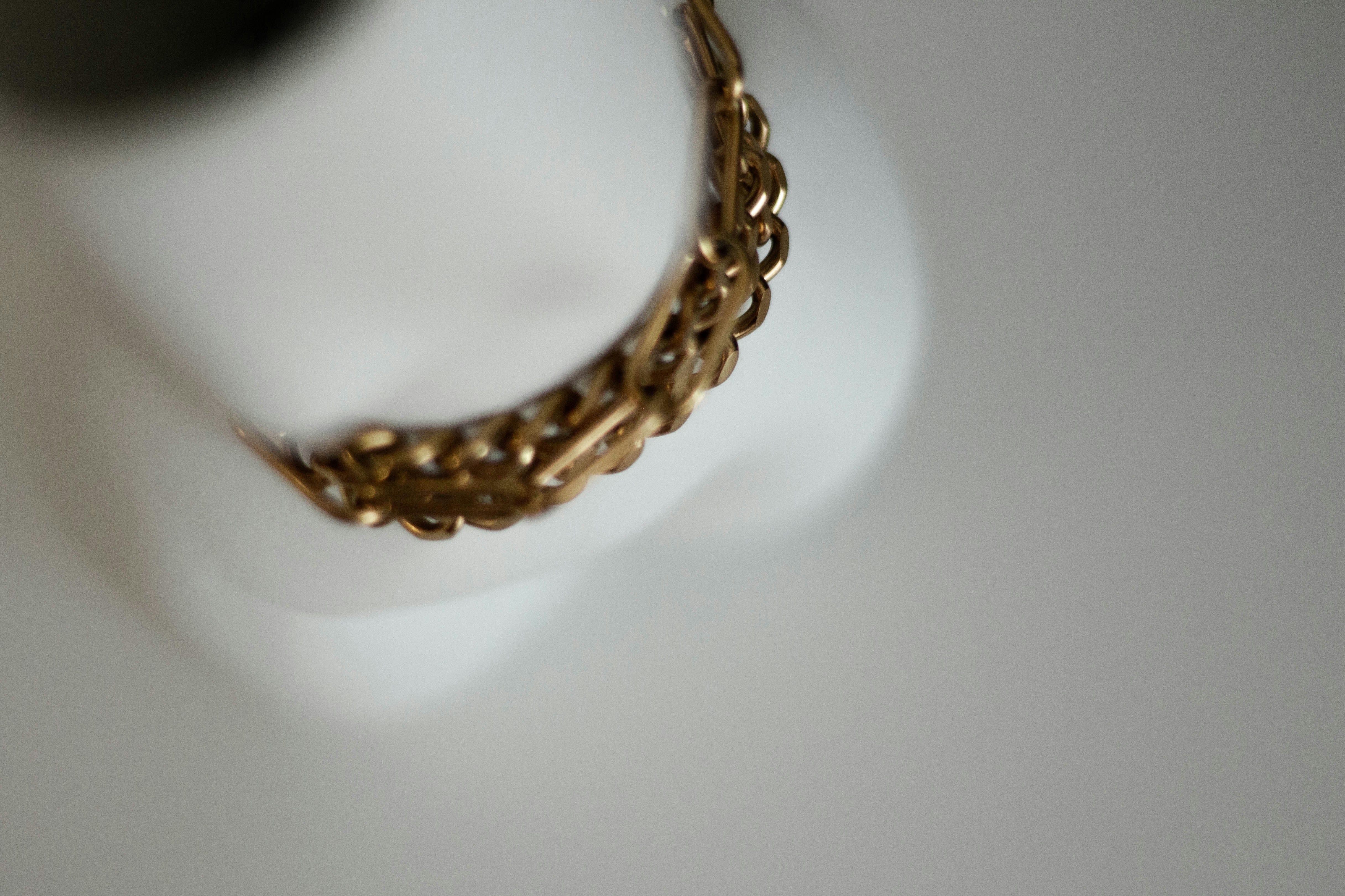 a gold chain on a white surface