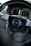 A close-up view of a car steering wheel, prominently featuring a brand logo labeled 'personal' in the center. The dashboard in the background shows the speedometer and other gauges.