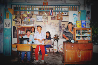 A lively vintage clothing vendor booth bustling with happy customers under warm, retro lighting.