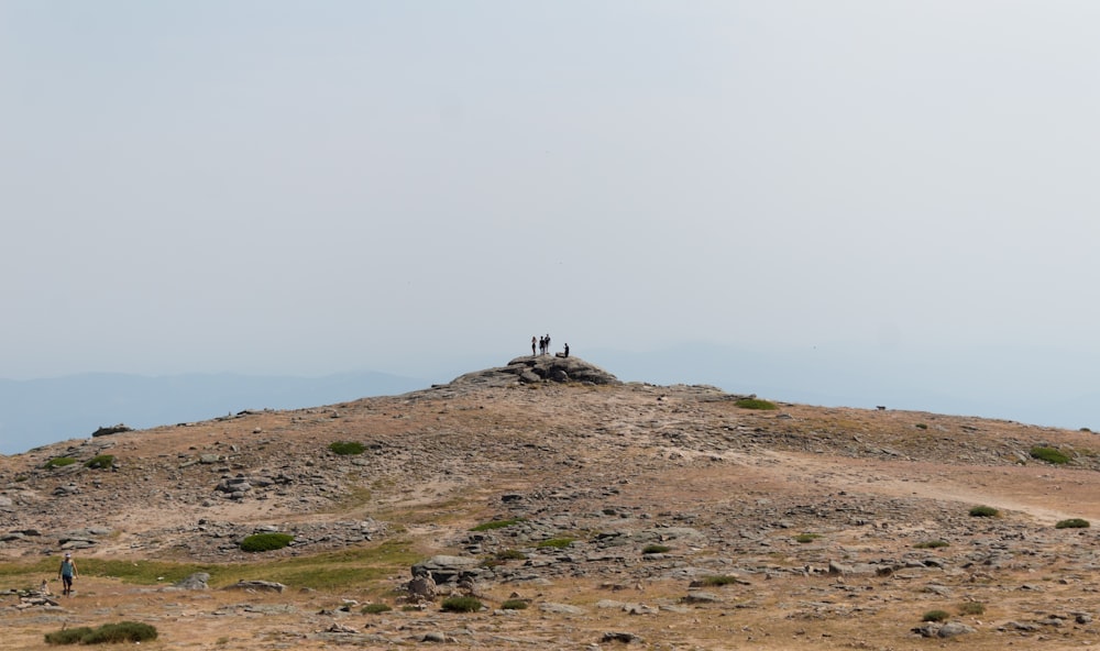 a group of people walking on a hill