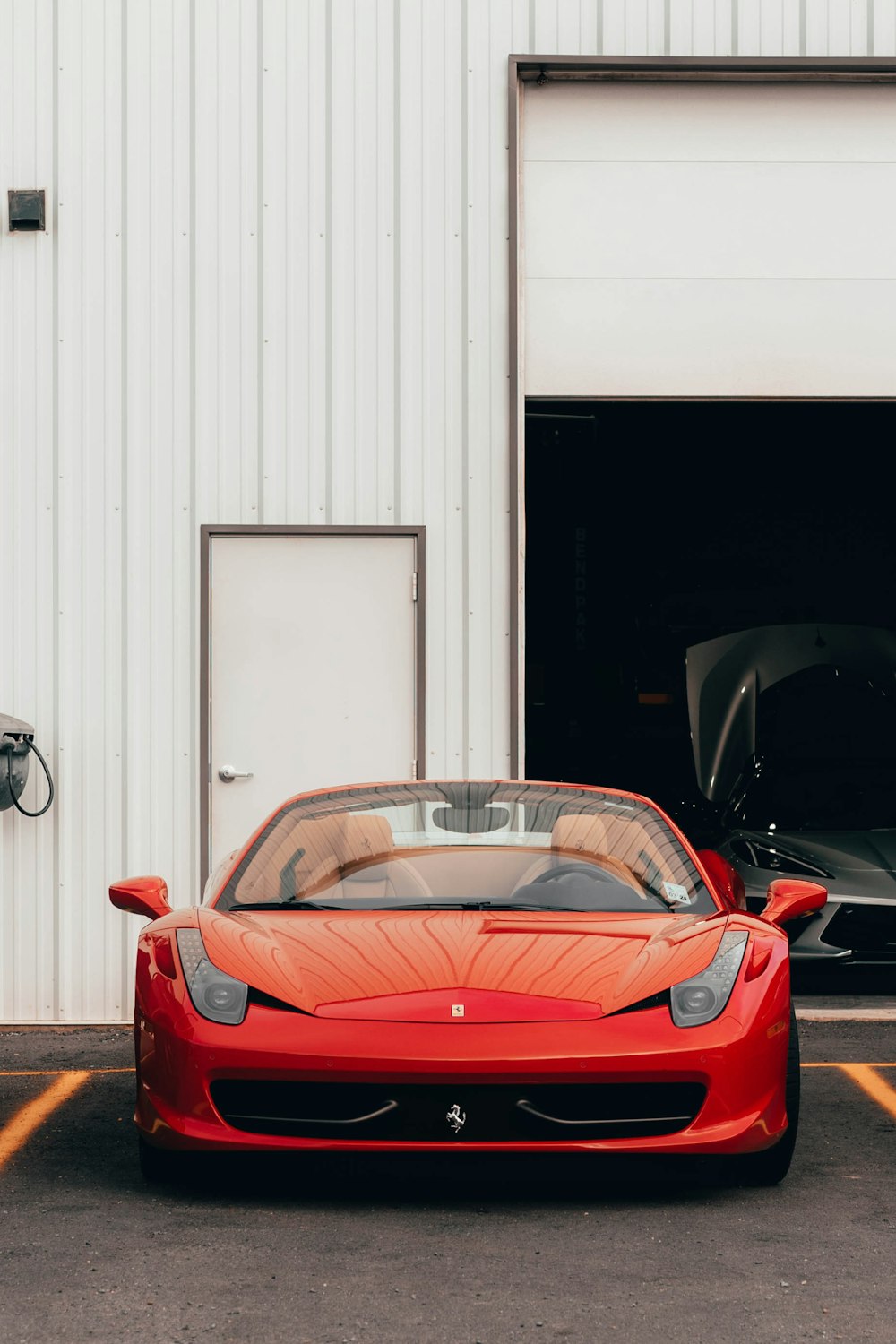 a red sports car parked in front of a garage