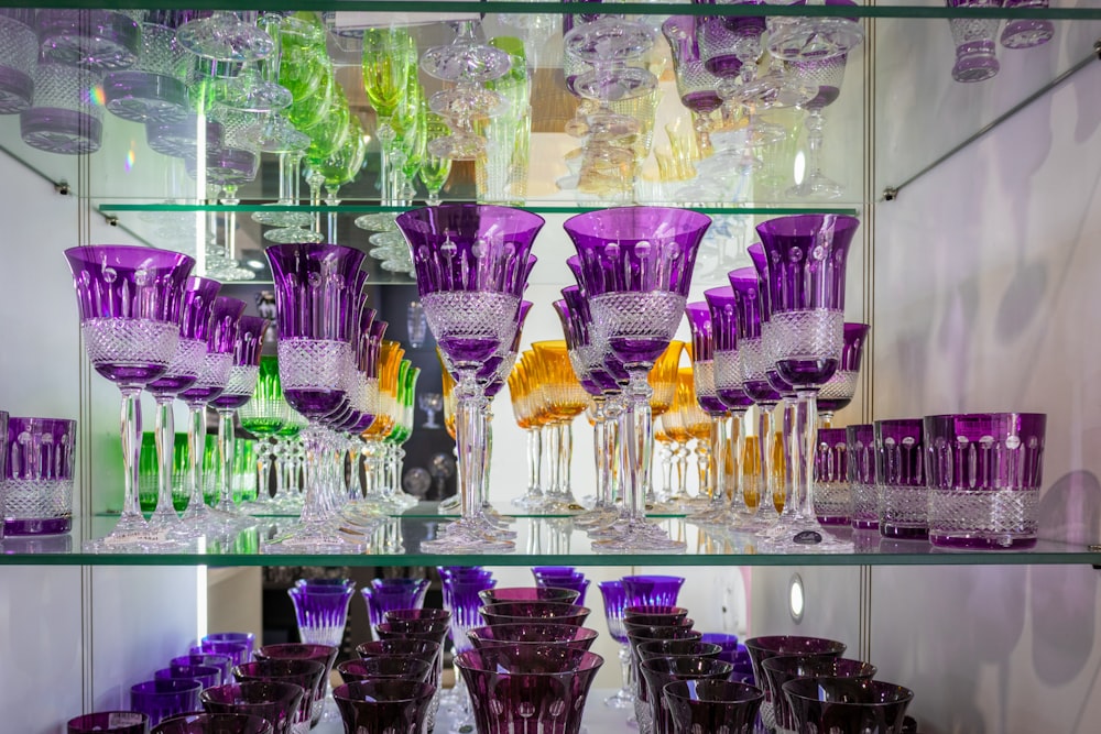a group of glass vases are on a shelf