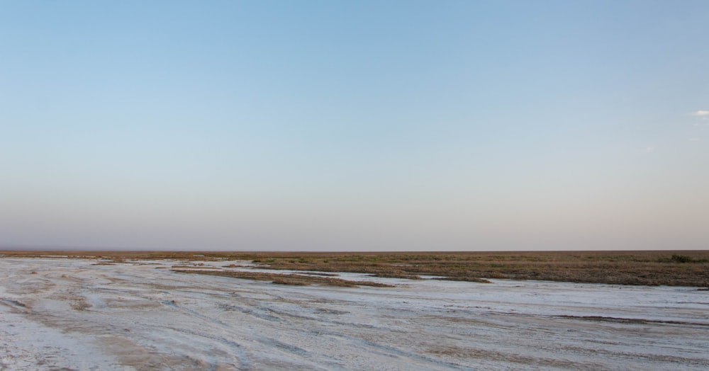 a large flat area with a body of water in the distance