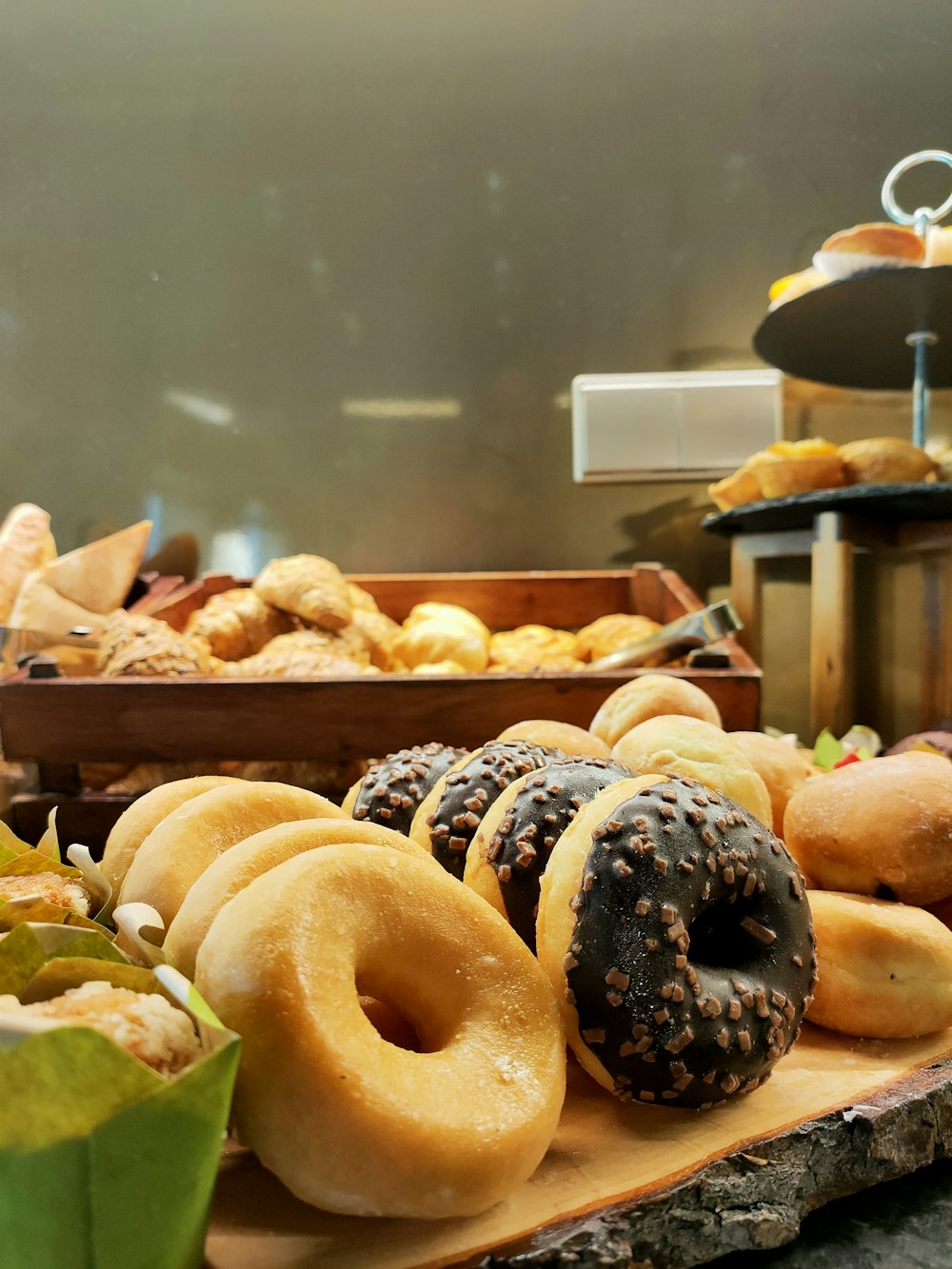 a variety of doughnuts are displayed in a bakery