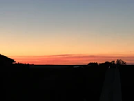 A clean post card featuring a user sharing a sunset photo with like, comment, and share buttons below.