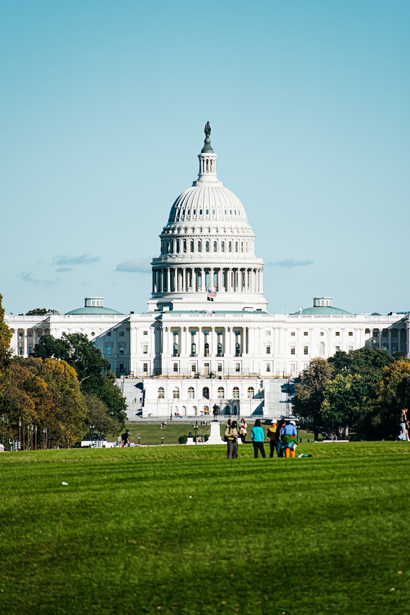 The United States Capitol building in Washington DC with green lawn in the foreground