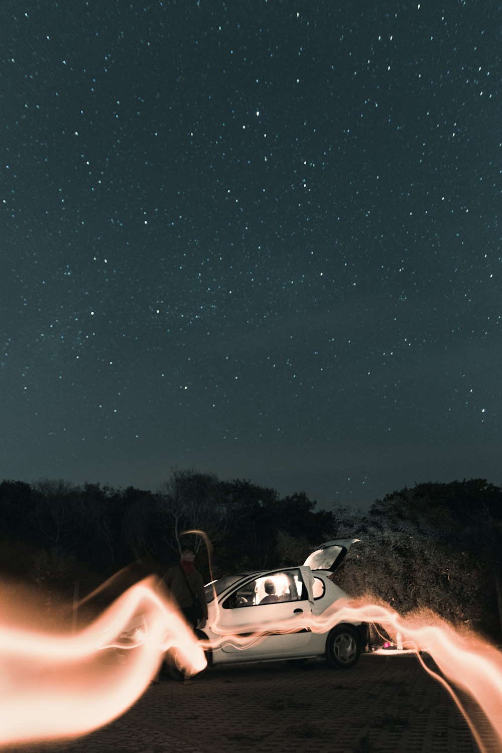 a person holding a car in the air with a starry sky above