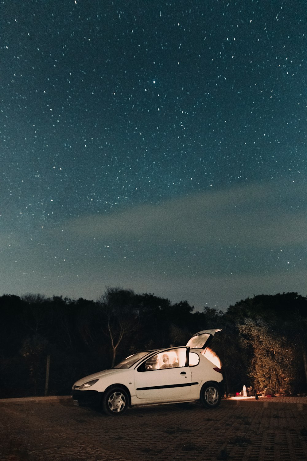 Un'auto parcheggiata su una strada con un cielo stellato sopra foto –  Algarve Immagine gratuita su Unsplash
