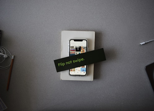 Close-up of a hand swiping on a phone screen displaying colorful lesson cards.
