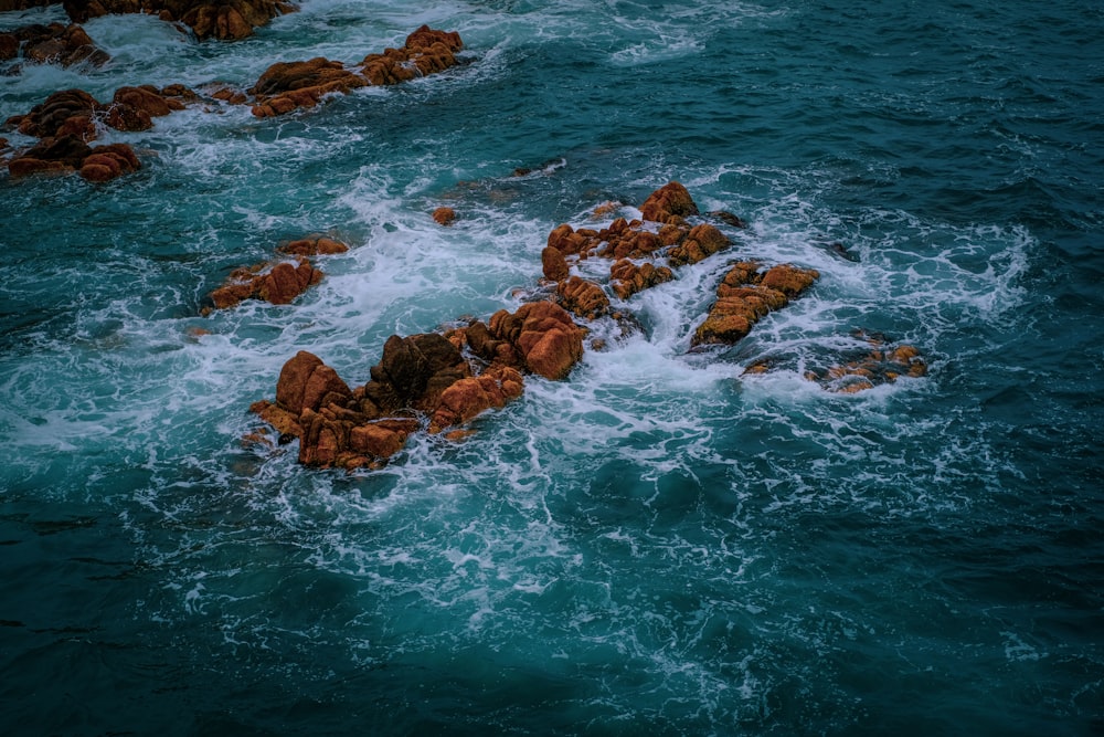 a rocky beach with a body of water in the background