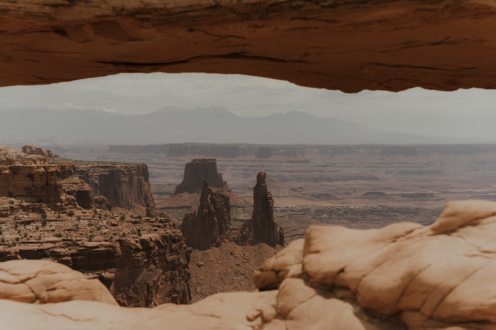 a rocky cliff with a body of water in the background