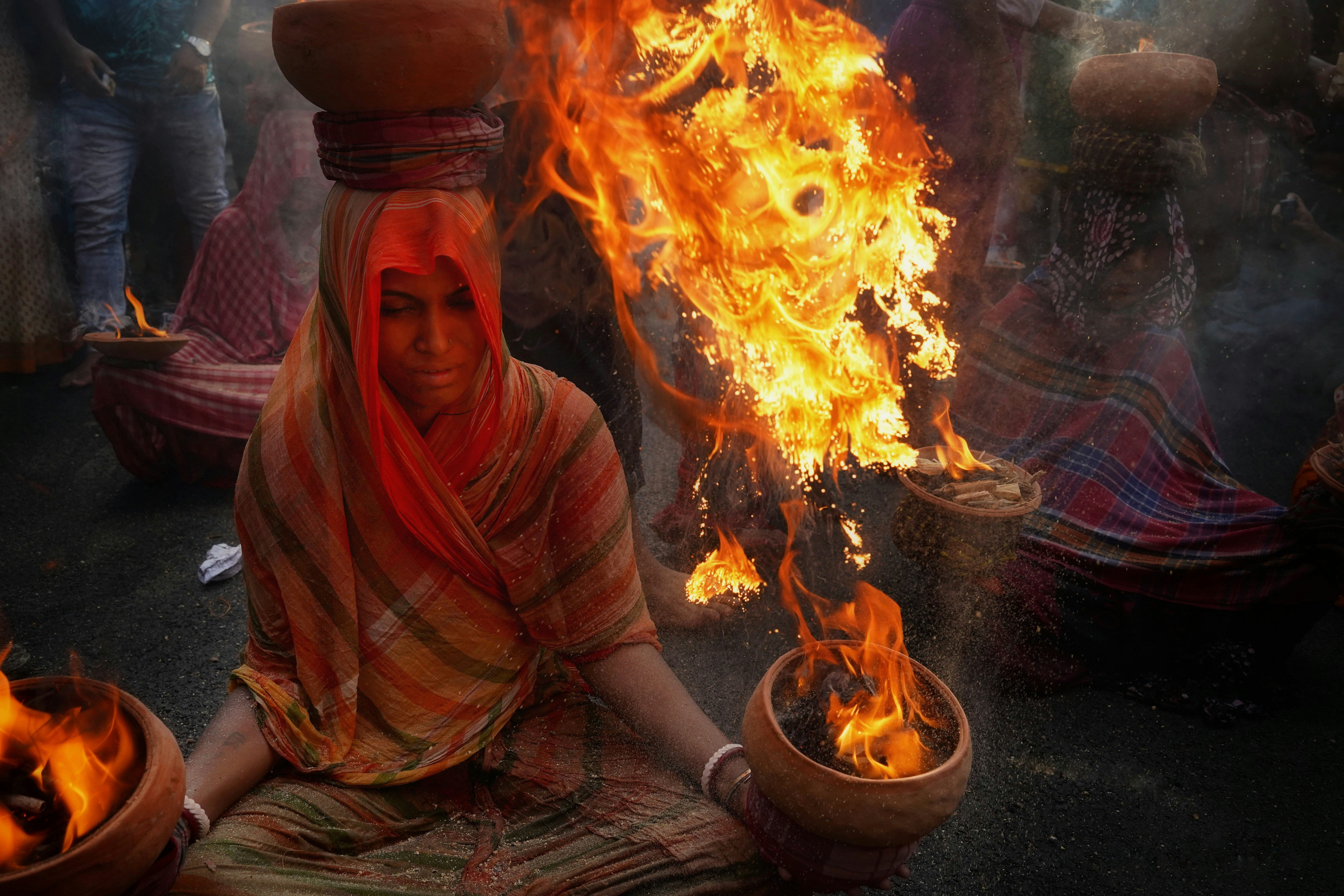 힌두 여성이 사원 내에서 유등으로 아아르티 의식을 수행하고 있습니다