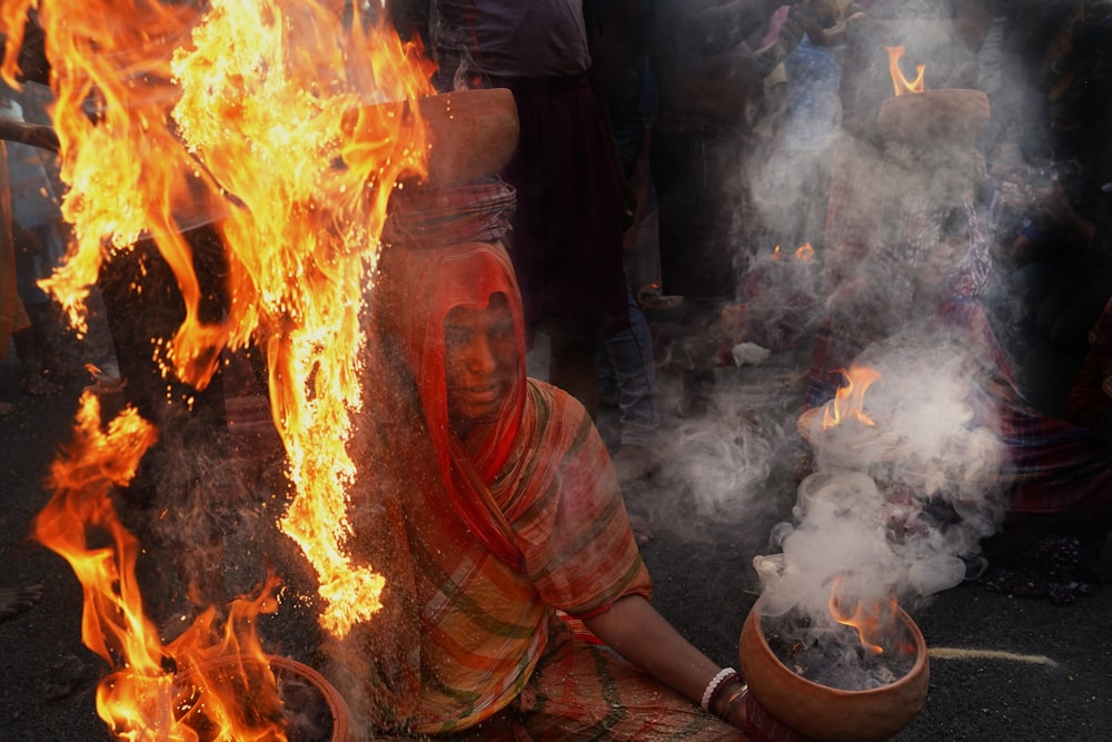 a person sitting next to a fire