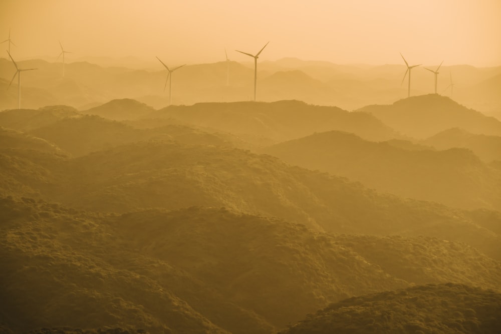 a group of wind turbines on a hill