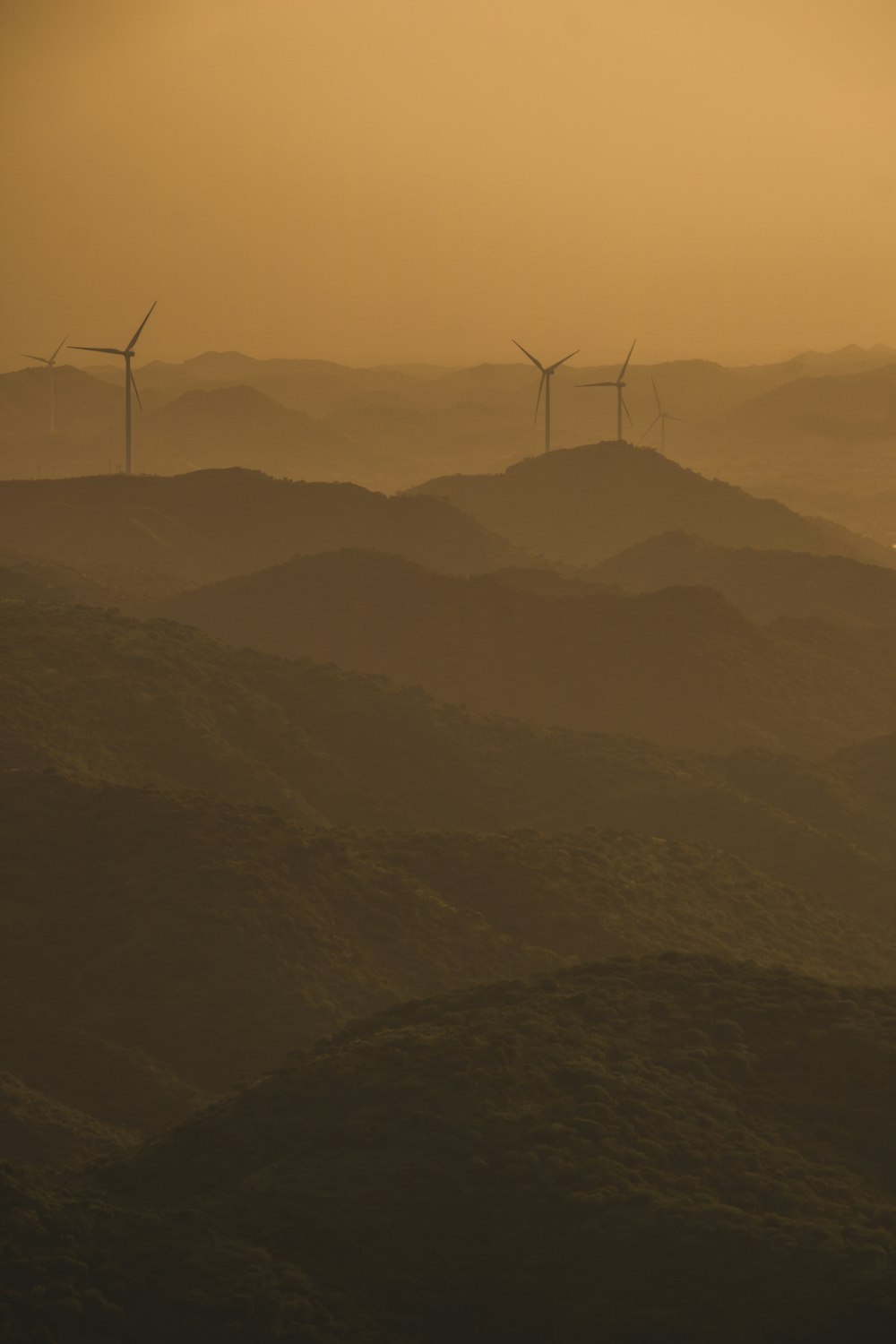 a group of wind turbines on a hill