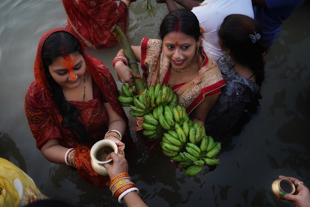 a couple of women holding bananas