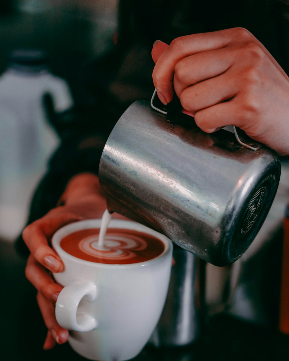 a person pouring a liquid into a cup