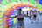 A cheerful customer holding a colorful party decoration in a sunny backyard.