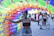 A cheerful customer holding a colorful party decoration in a sunny backyard.