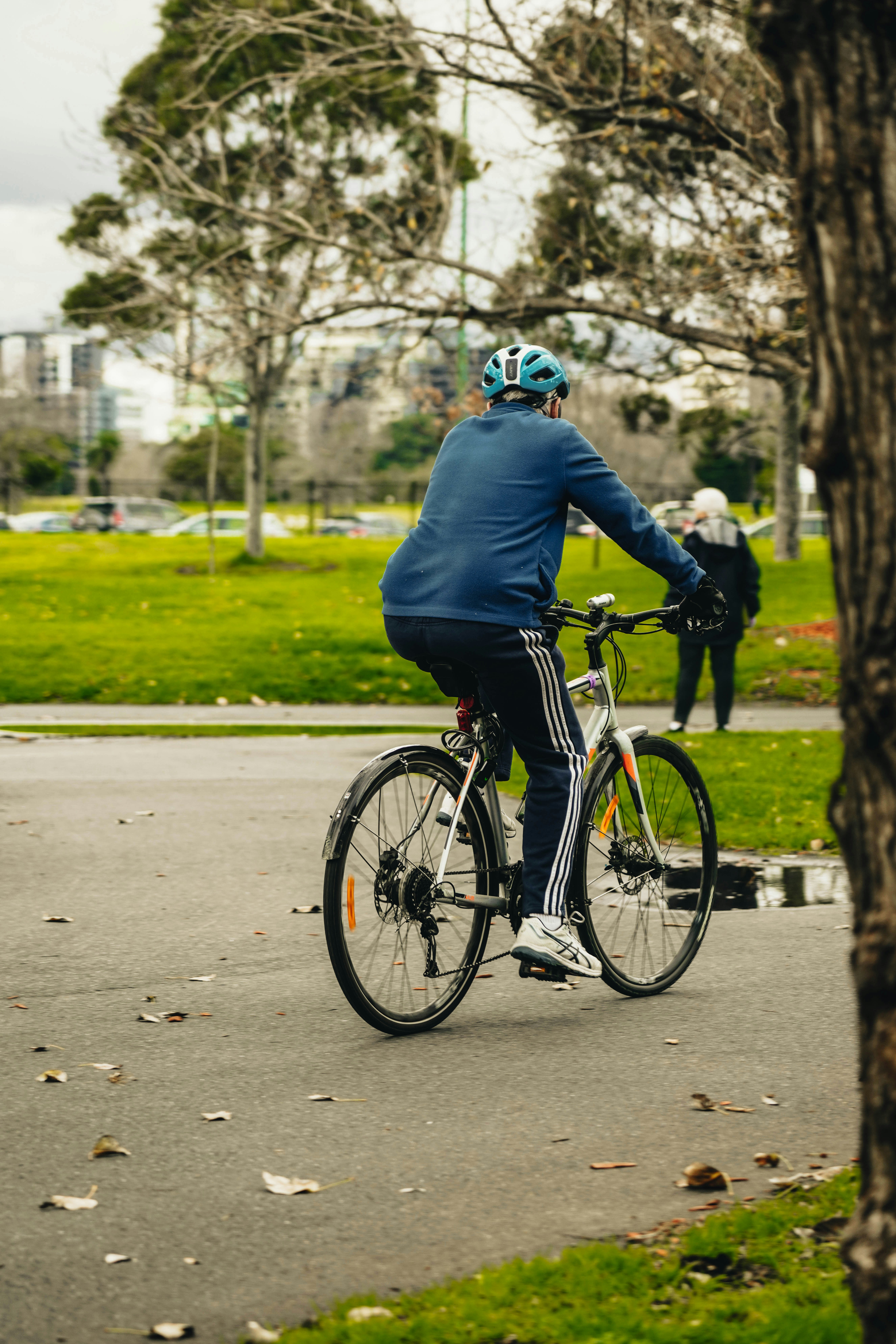 a person riding a bicycle on a path with trees and grass