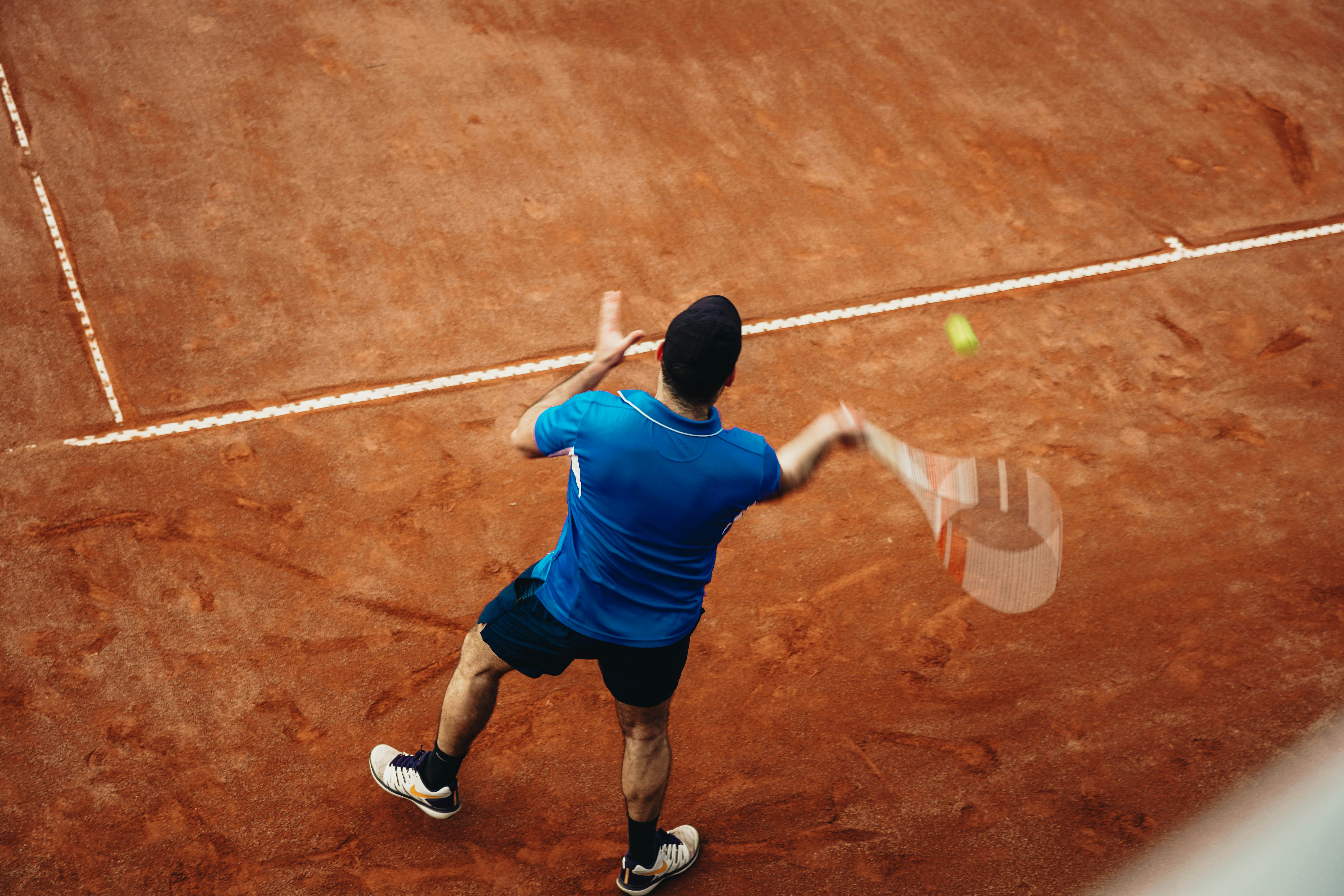 a man hitting a tennis ball with a racket