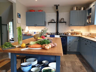 A freshly renovated kitchen with navy blue cabinets, white countertops, and warm orange accents.