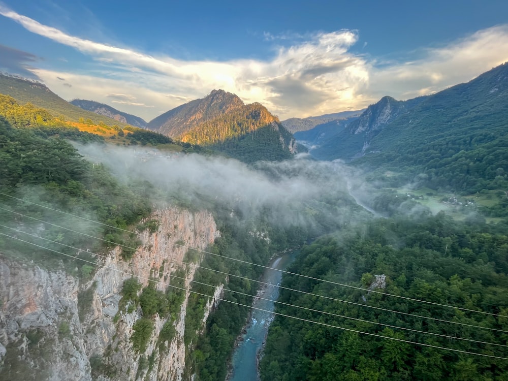 un valle con un río que lo atraviesa y montañas al fondo