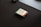 A small electronic device, likely a microcontroller or a sensor, is placed on a dark surface. It has a green circuit board and is labeled with 'Elementz.' There are visible components, including a small rectangular screen or panel.
