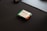 A small electronic device, likely a microcontroller or a sensor, is placed on a dark surface. It has a green circuit board and is labeled with 'Elementz.' There are visible components, including a small rectangular screen or panel.