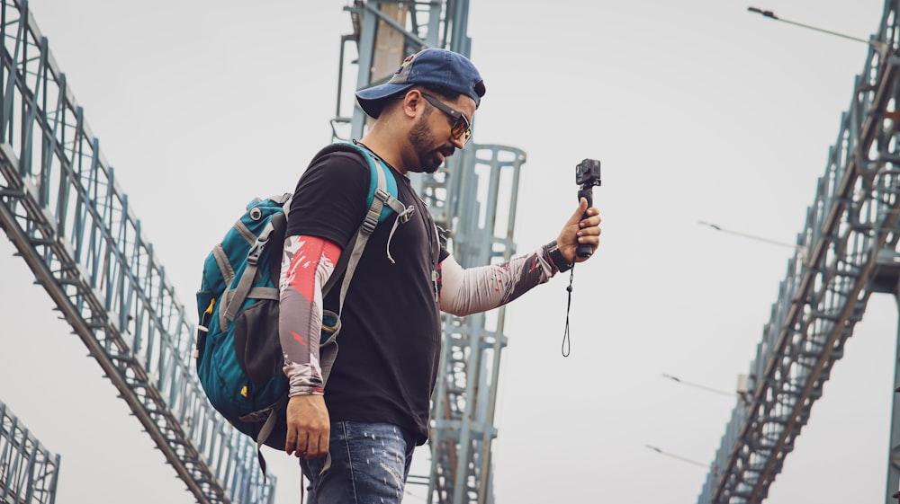 a man with a backpack and a backpack walking on a bridge