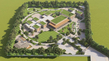 An aerial view of a modern architectural estate, featuring multiple buildings with green rooftops and a central courtyard. The estate is surrounded by lush greenery and palm trees, and the pathways are neatly arranged. There are manicured lawns and landscaped gardens throughout the property.