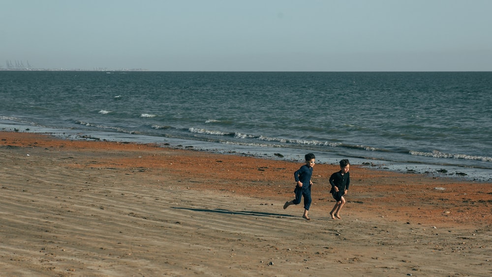 two people running on a beach