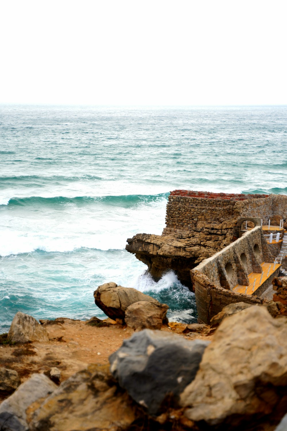 a rocky beach with a body of water in the background