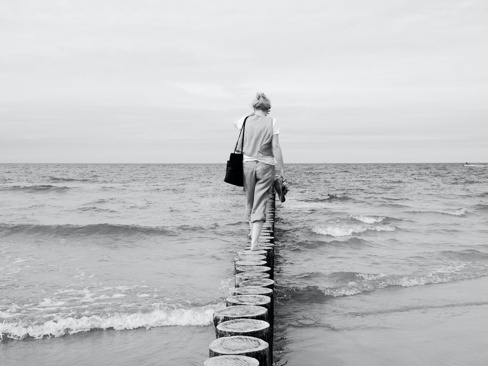 a man walking on a stone path by the ocean