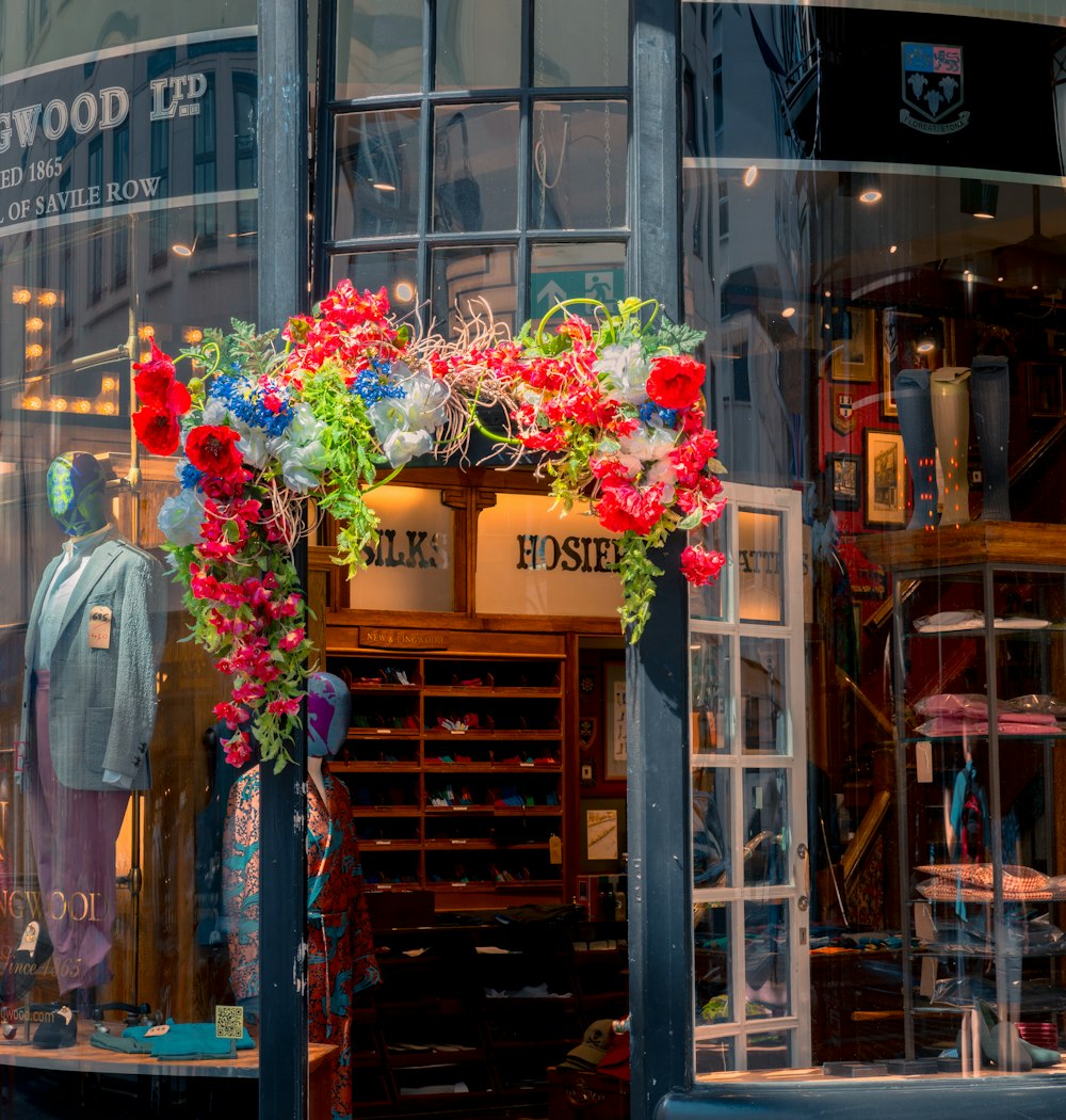 a display of flowers in front of a storefront