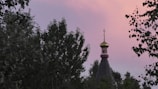 A peaceful sunset behind a church steeple with a cross