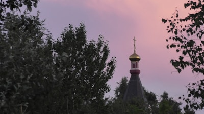 A peaceful sunrise over a quiet church surrounded by trees, symbolizing hope and faith.