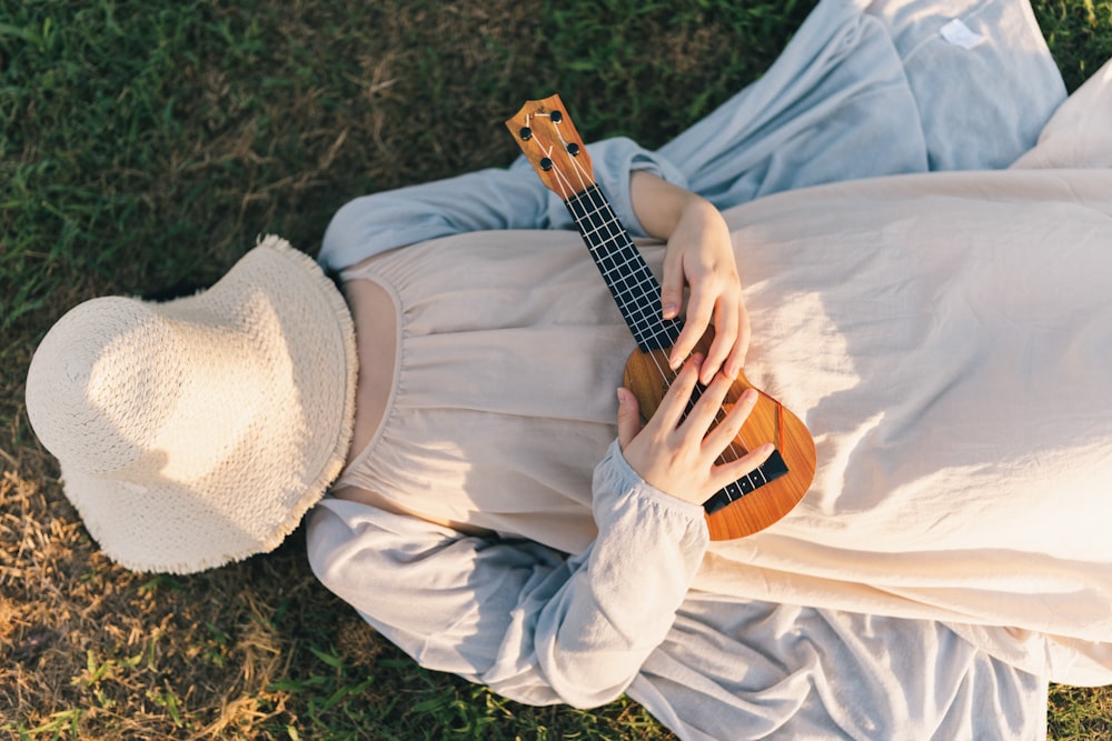 a person lying in a blanket playing a guitar