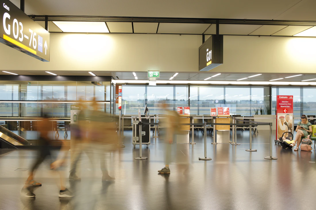 Travellers moving through a bright modern airport departures terminal
