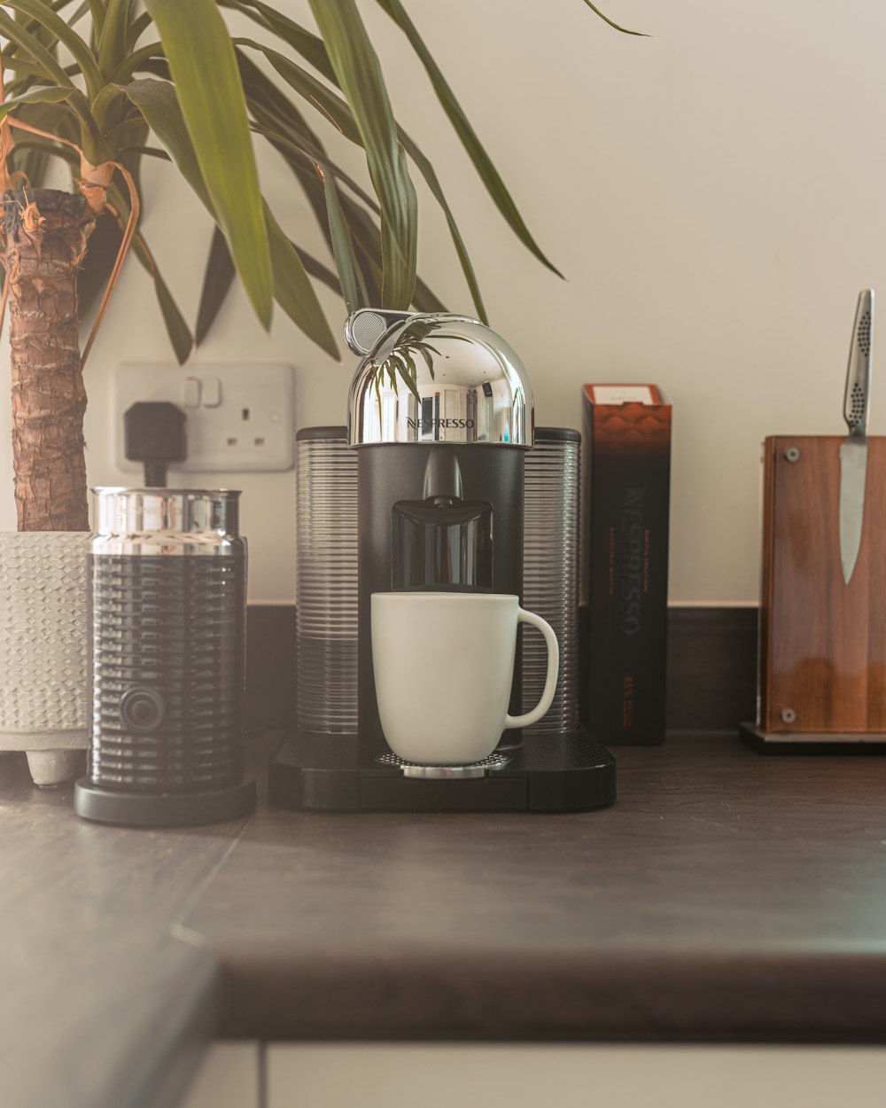 a coffee maker and a mug on a table