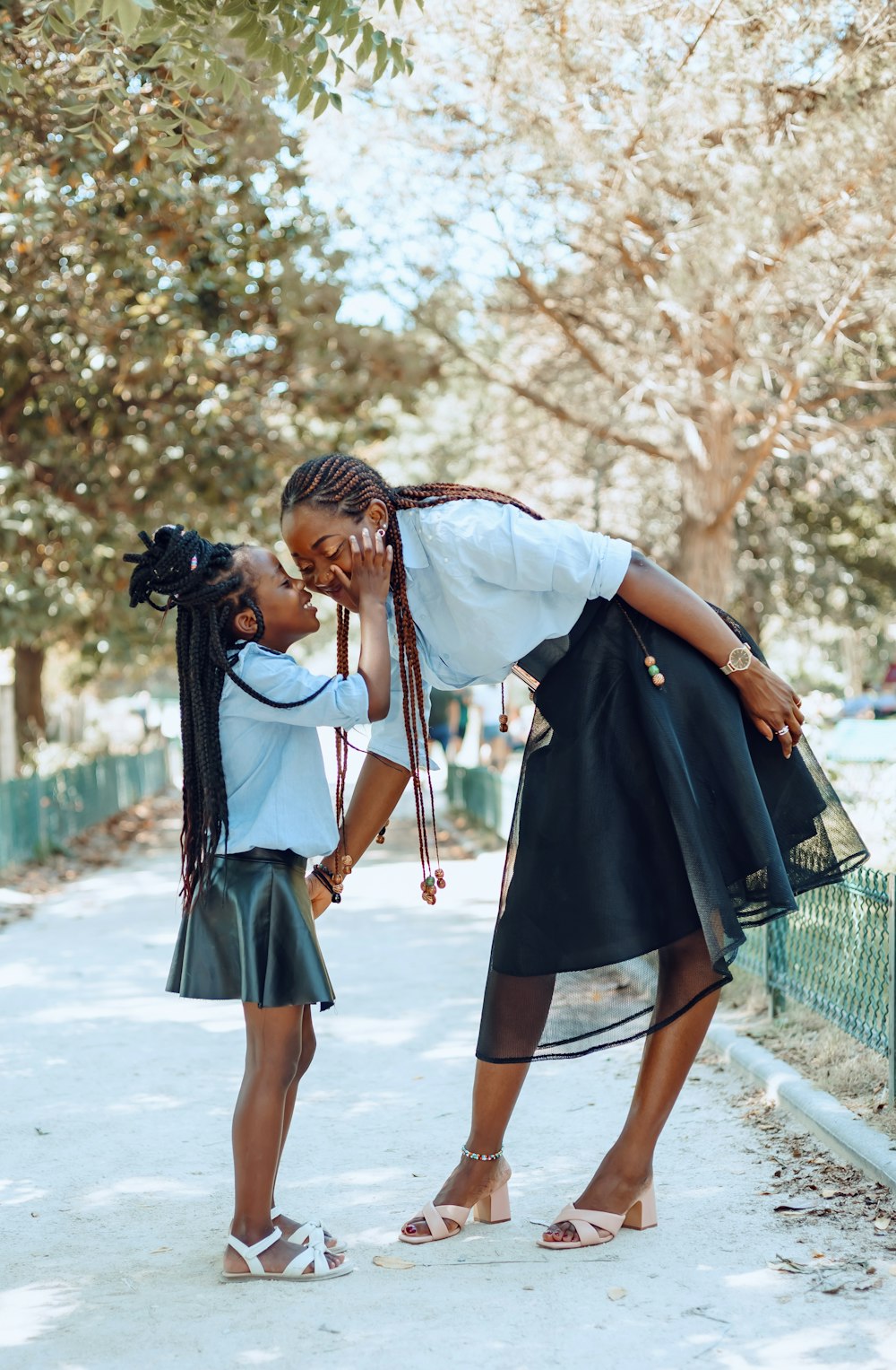 a person kissing another woman on the cheek