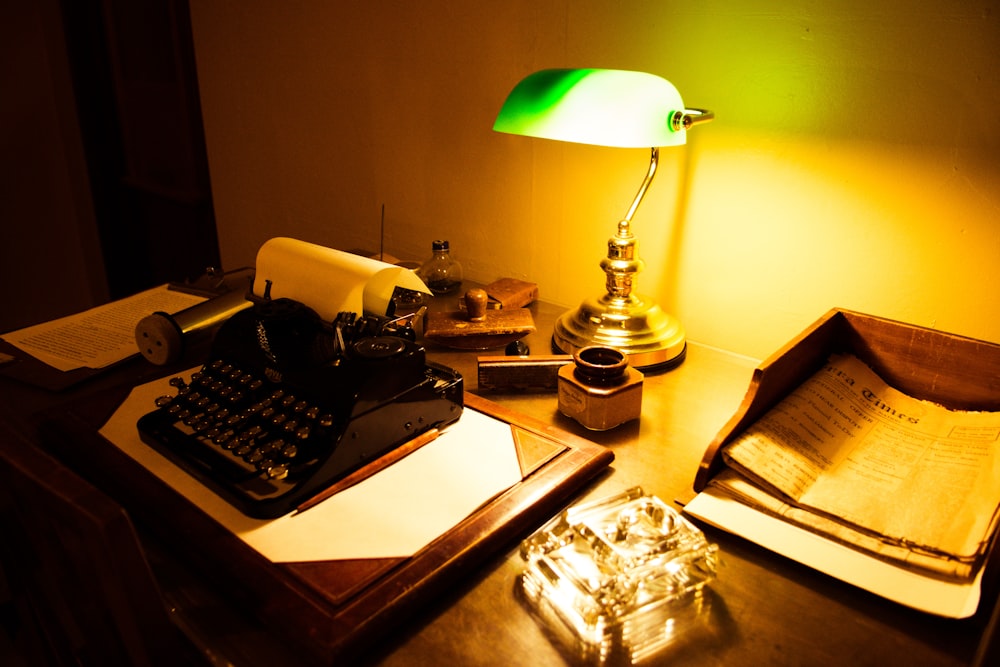 a typewriter and a lamp on a table