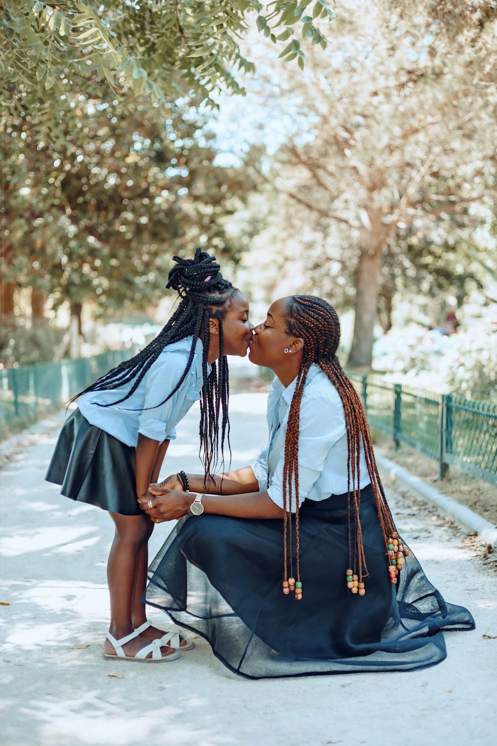 a person kissing another woman on the cheek