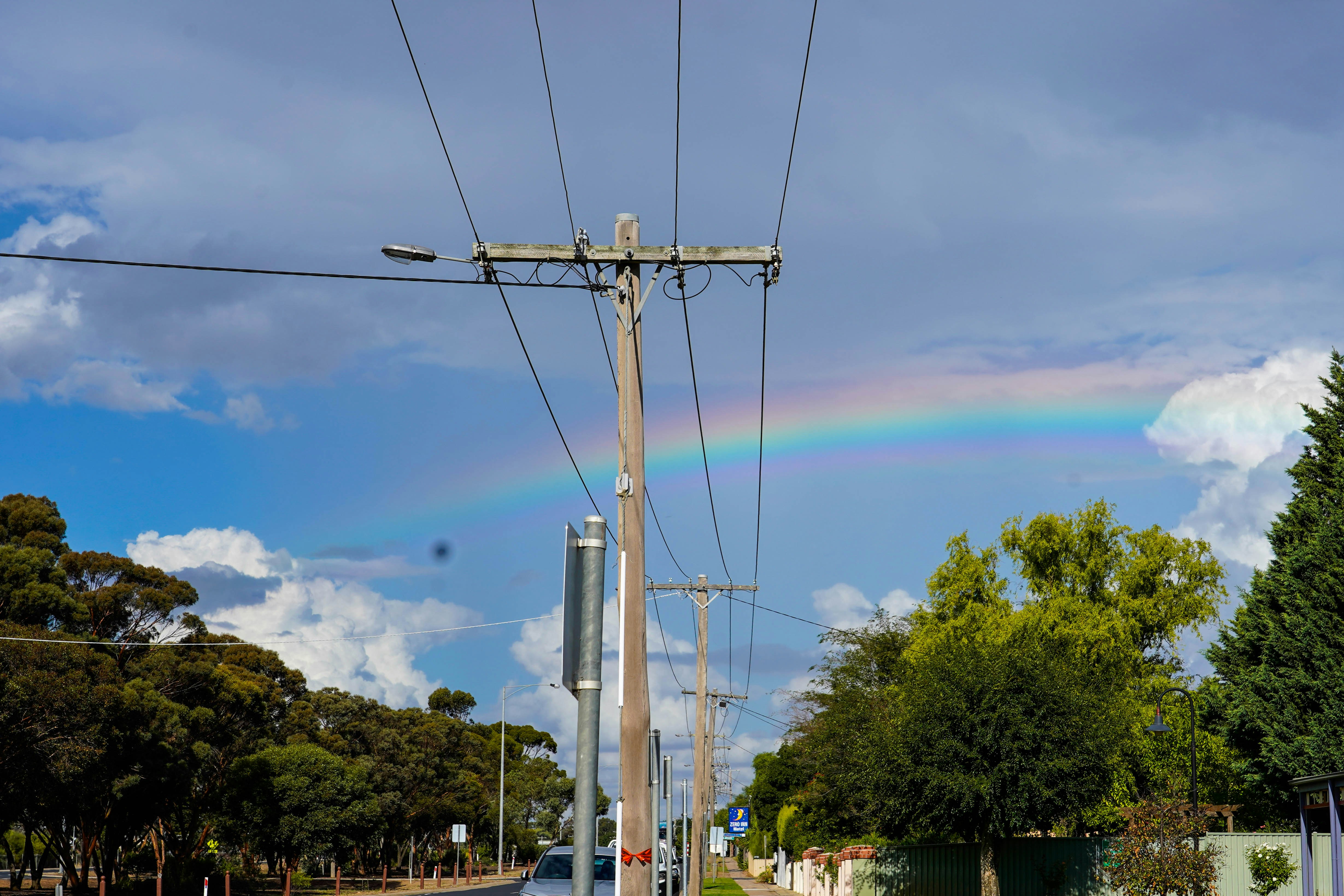 a power line with trees and a blue sky